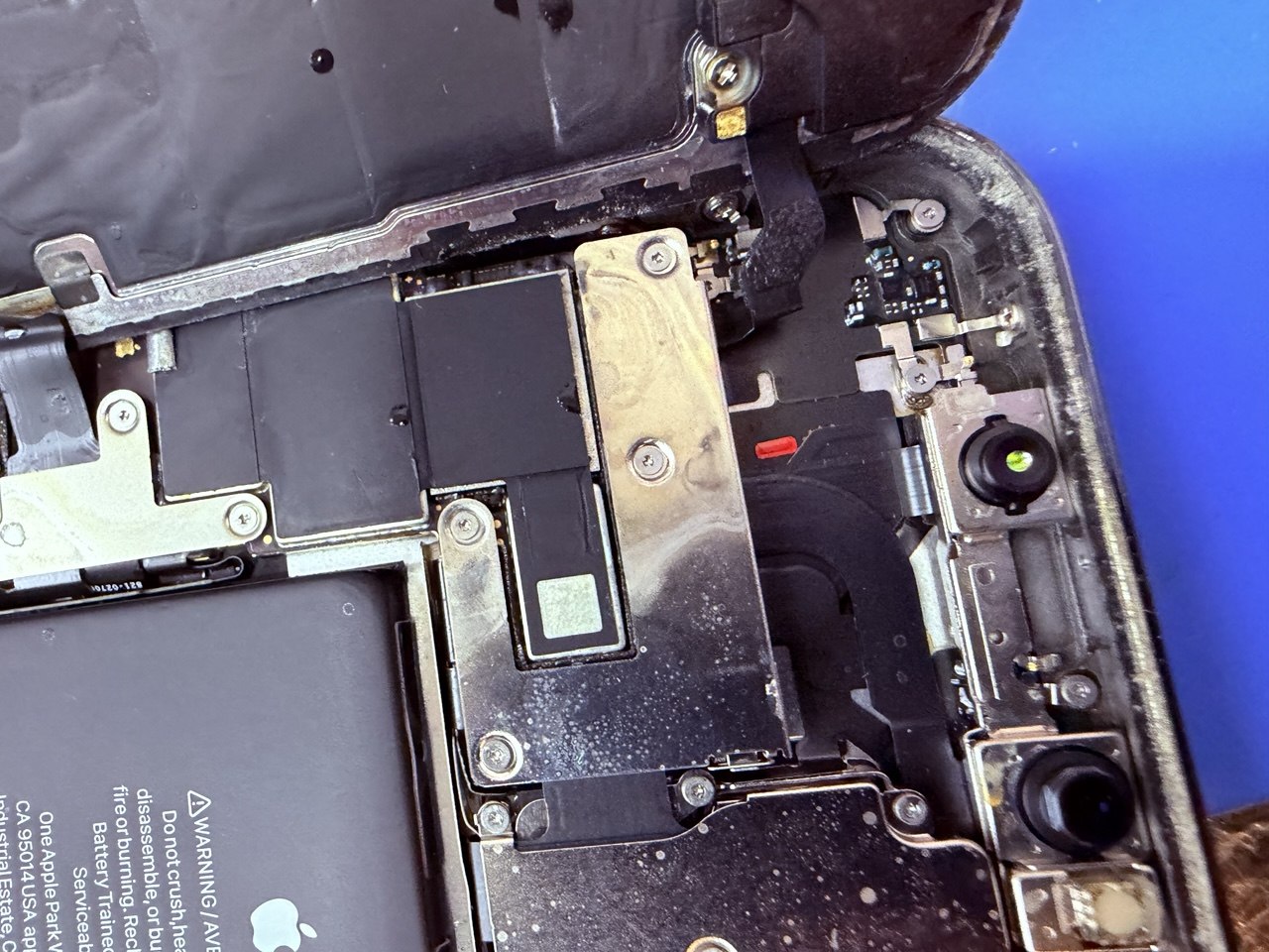 Placa de iPhone con corrosión extendida por agua salada