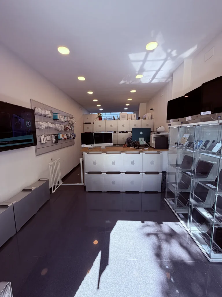 Interior de la tienda de ReciclaTecnologia en Sant Antoni (Barcelona): mostrador con cajas de Mac Pro y vitrinas de equipos Apple