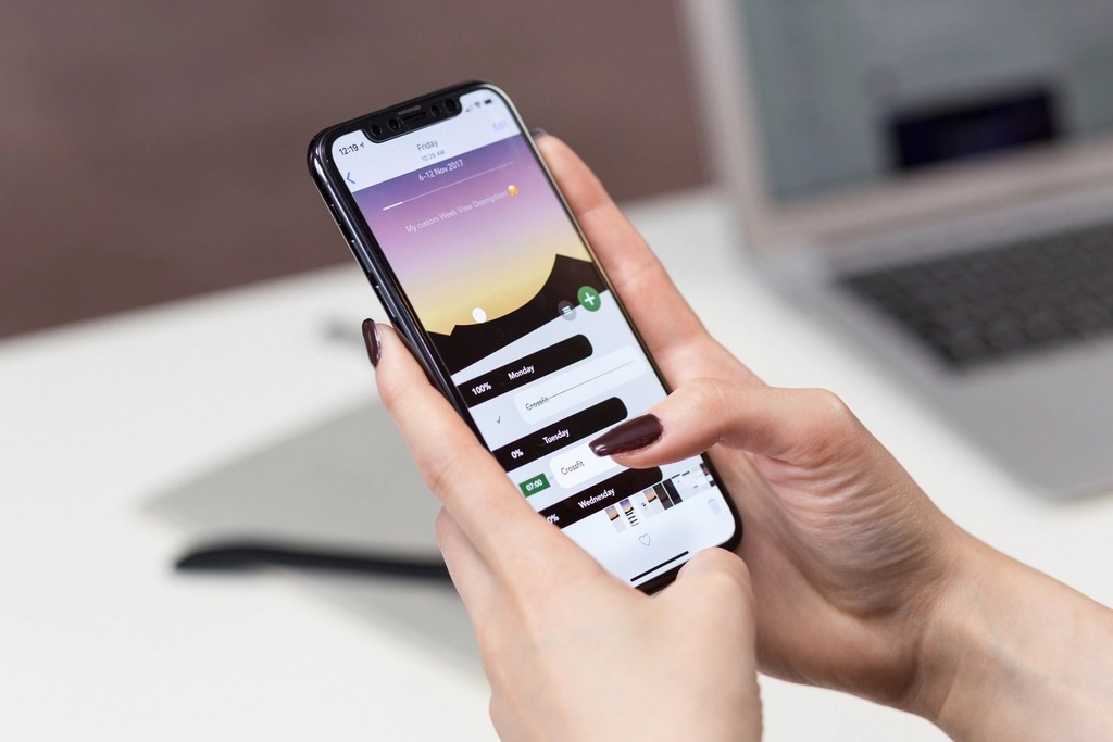 iPhone en la mano usando una app de mensajería — novedades de Mensajes en iOS 27