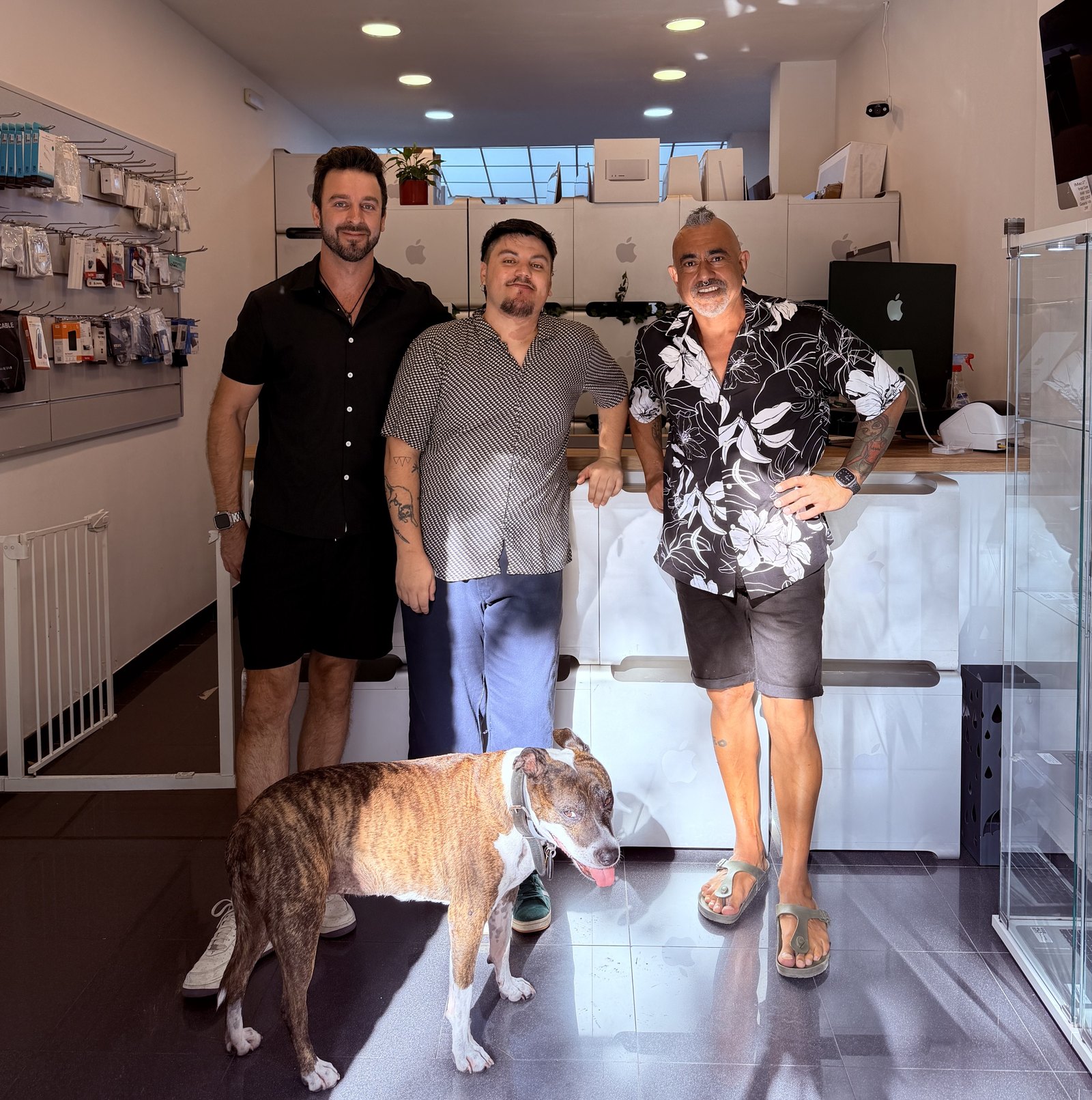 Juan Martín, Pancho y Javi, el equipo de ReciclaTecnología, con la perra Piña en la tienda de Sant Antoni (Barcelona)