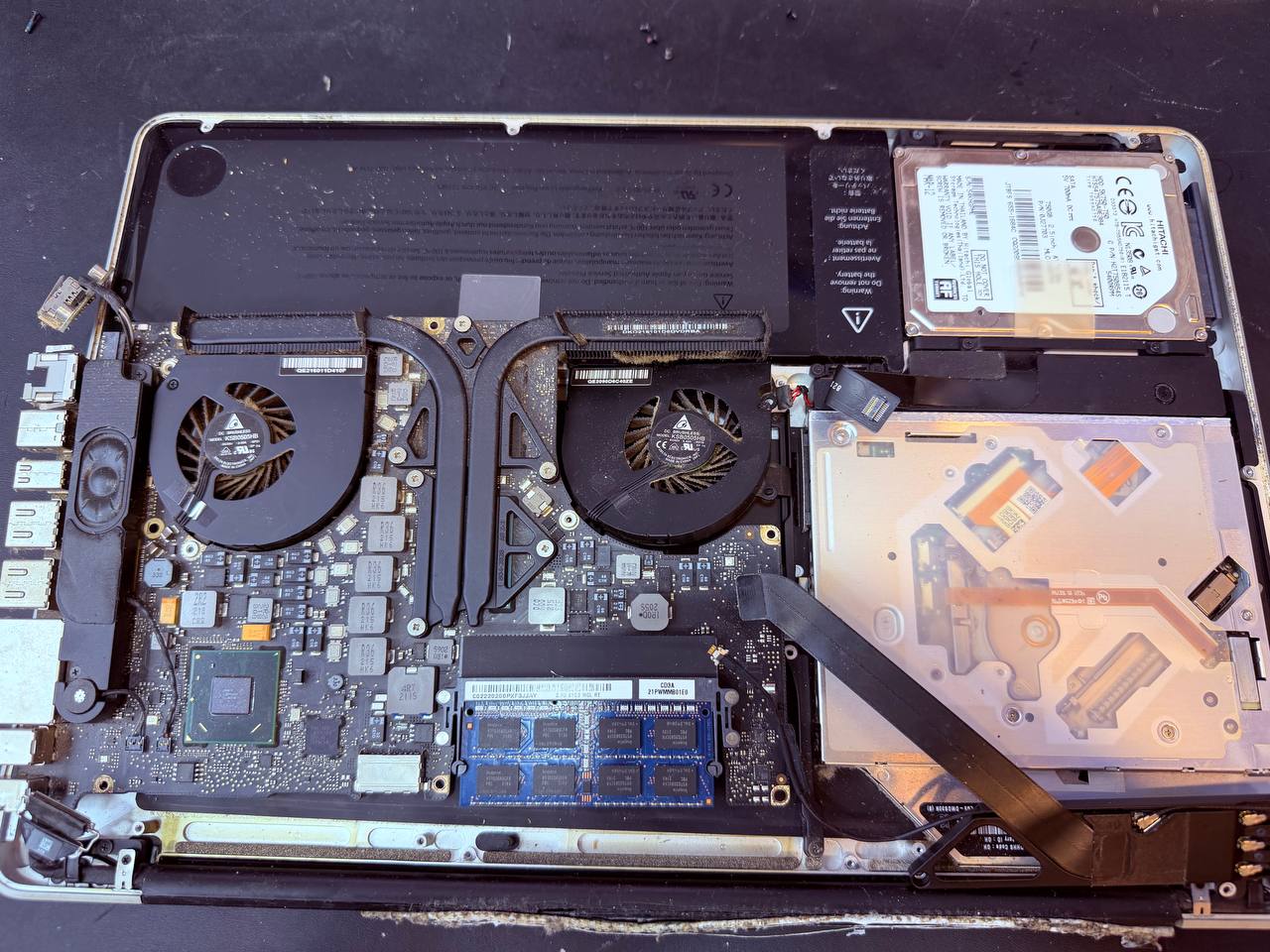 Interior de MacBook Pro con lectora SuperDrive y disco duro HDD Hitachi antes de la actualización