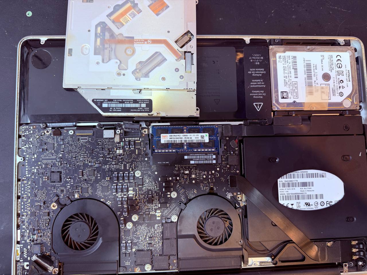 MacBook Pro con SuperDrive extraída — espacio libre para instalar SSD con caddy
