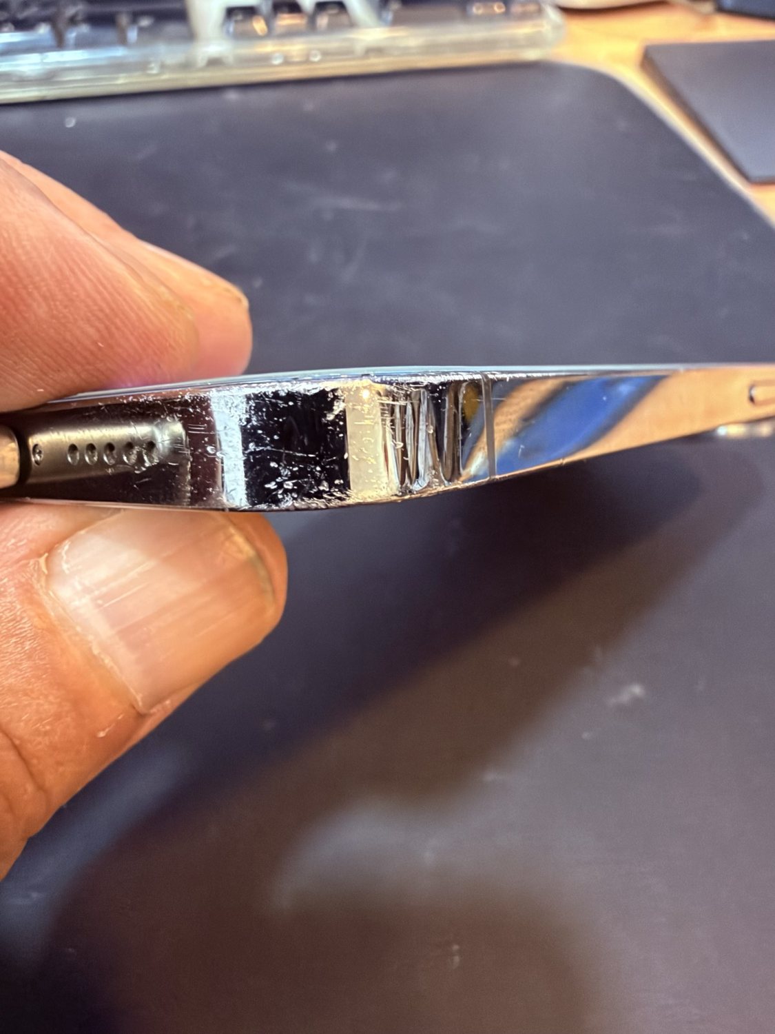 Canto de acero inoxidable de un iPhone de segunda mano con microrayas y roces de uso