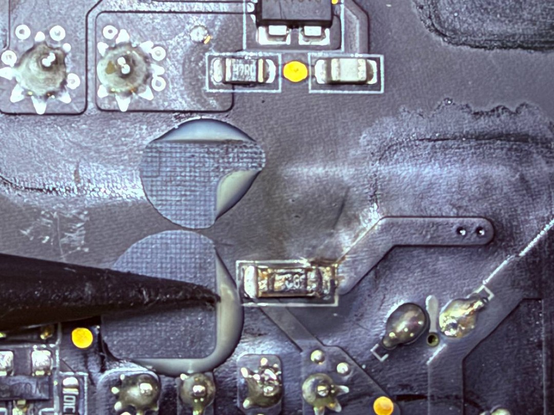 Vista de microscopio de una soldadura en la placa del Mac Studio, con pistas, pads y un componente de superficie recién trabajado