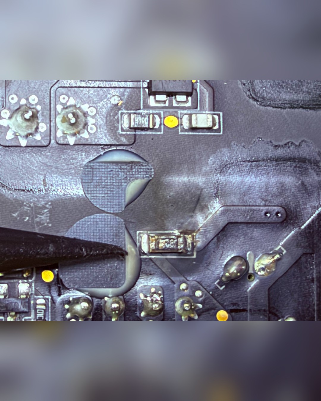 Detalle ampliado de la placa del Mac Studio con un componente resoldado y la punta de una herramienta